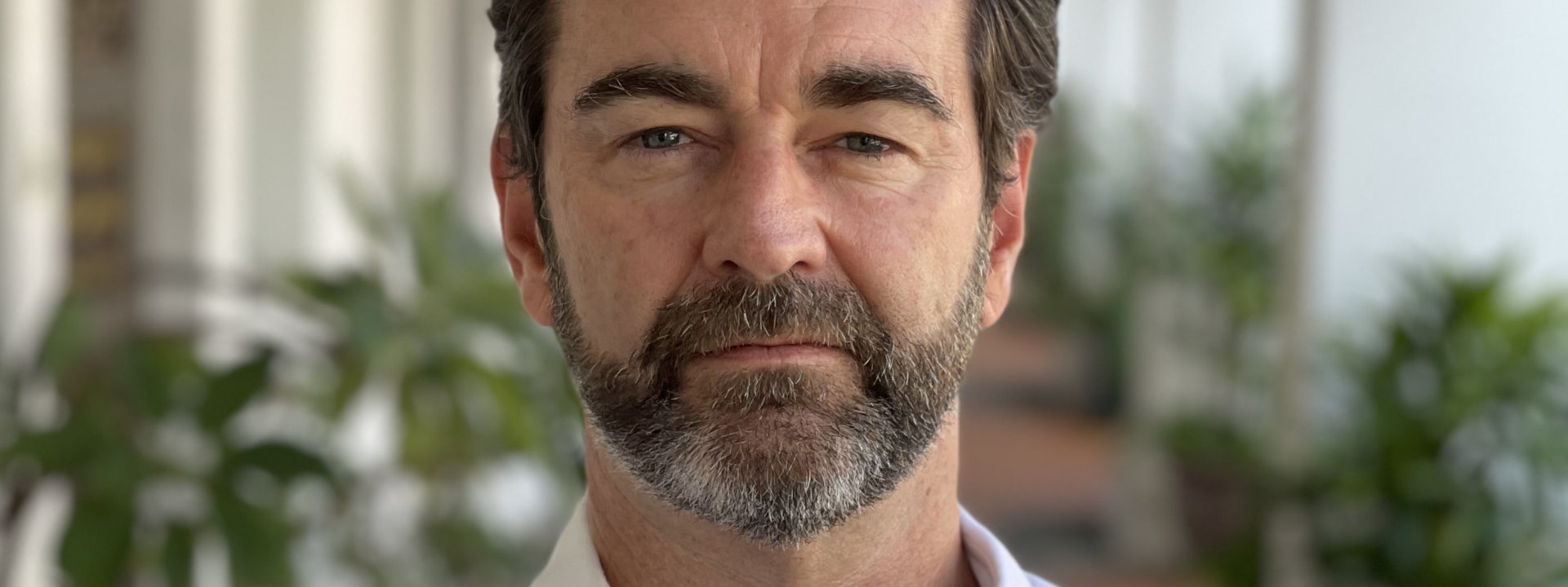 Craig Mapleston standing outside in a walkway in a white shirt