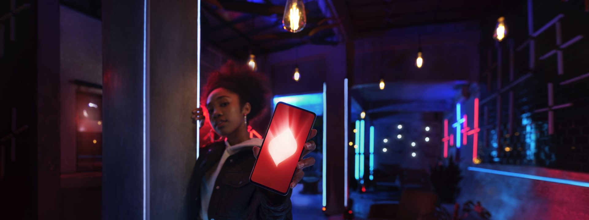 Lady holding phone in room with fluorescent lighting