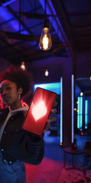 Lady holding phone in room with fluorescent lighting