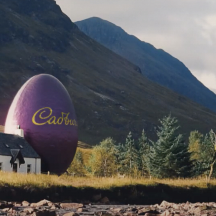 Countryside landscape scene with a giant purple Cadbury branded egg placed next to a house