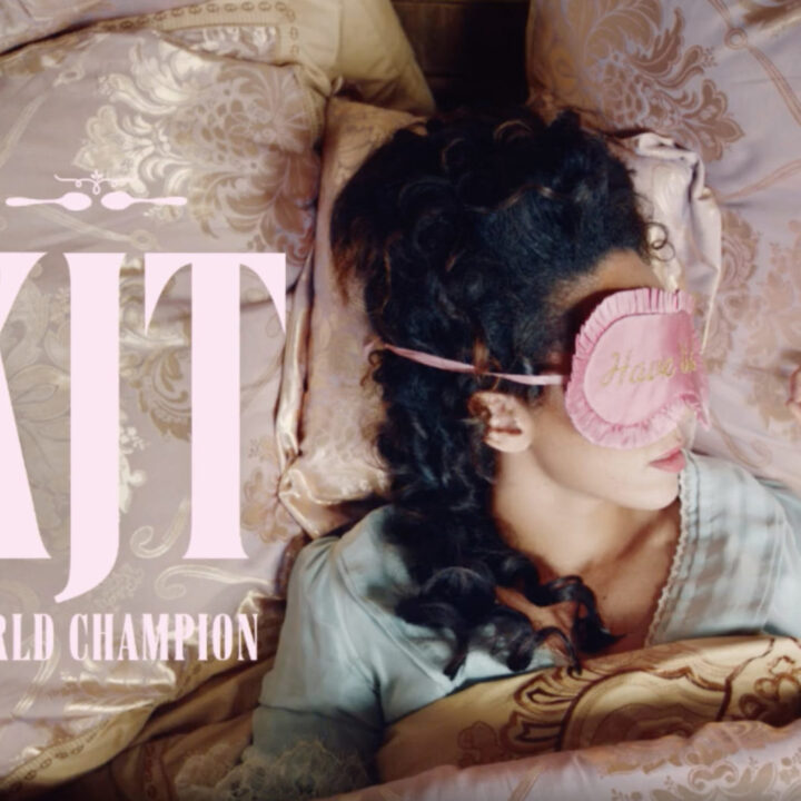 A woman wearing an eyemask asleep in silk sheets