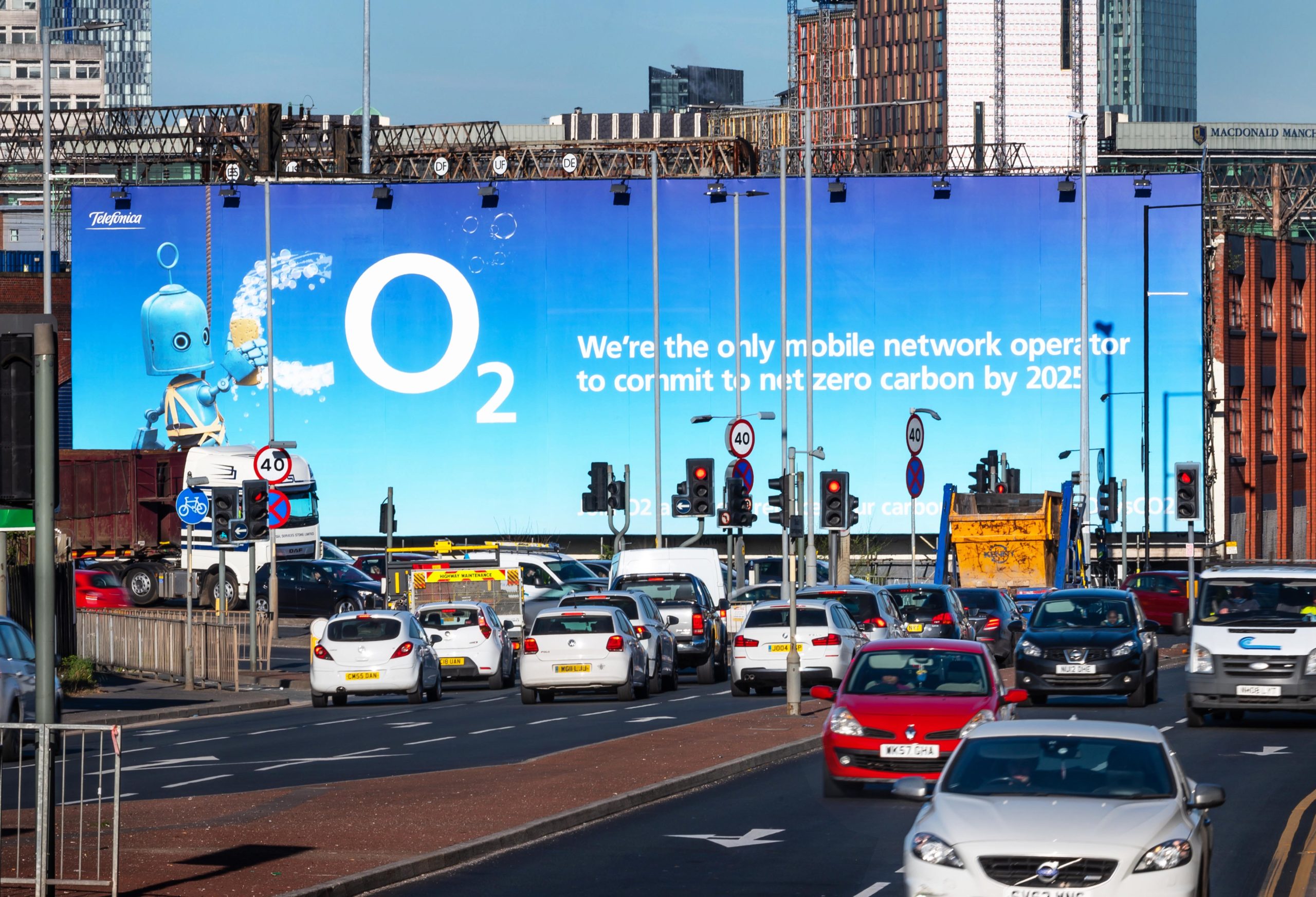 Traffic on a busy road with a billboard that reads Co2