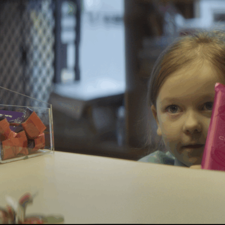 Closeup of a little girl holding a pink packaged chocolate bar