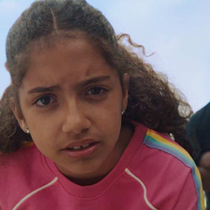 Young girl facing camera with adults in the background - Campaign for Prostate Cancer UK