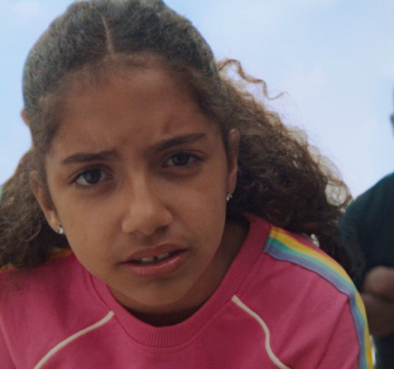 Young girl facing camera with adults in the background - Campaign for Prostate Cancer UK