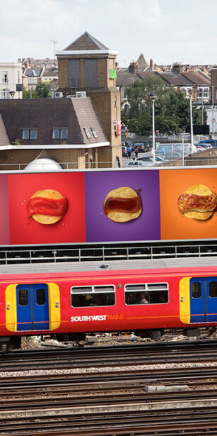 Train passing by large billboard with Walkers Crisp advert