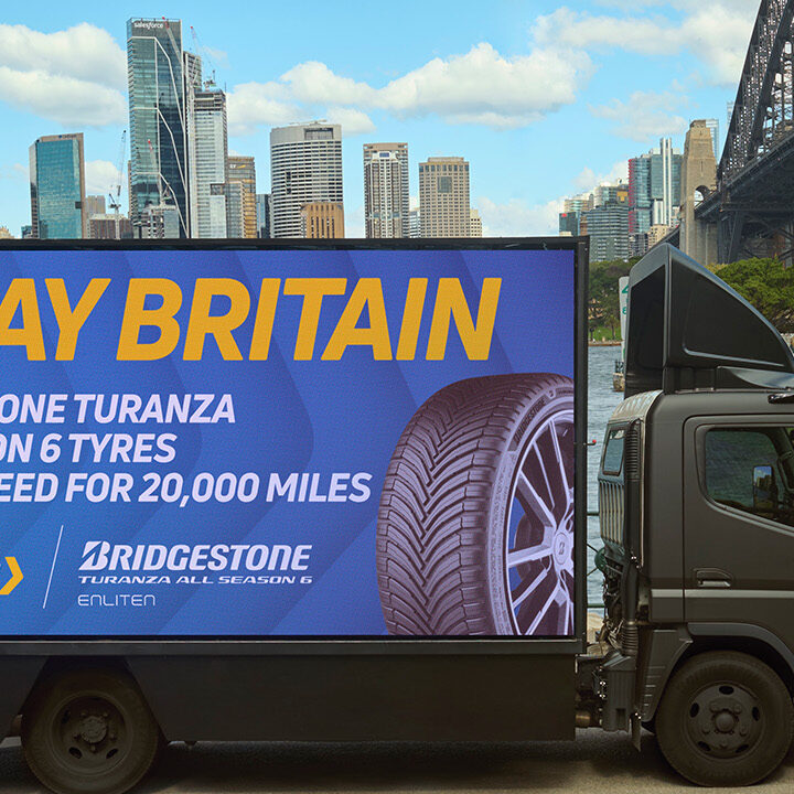 Lorry truck outside Sydney harbour bridge with Kwik Fit branding.