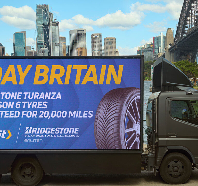 Lorry truck outside Sydney harbour bridge with Kwik Fit branding.