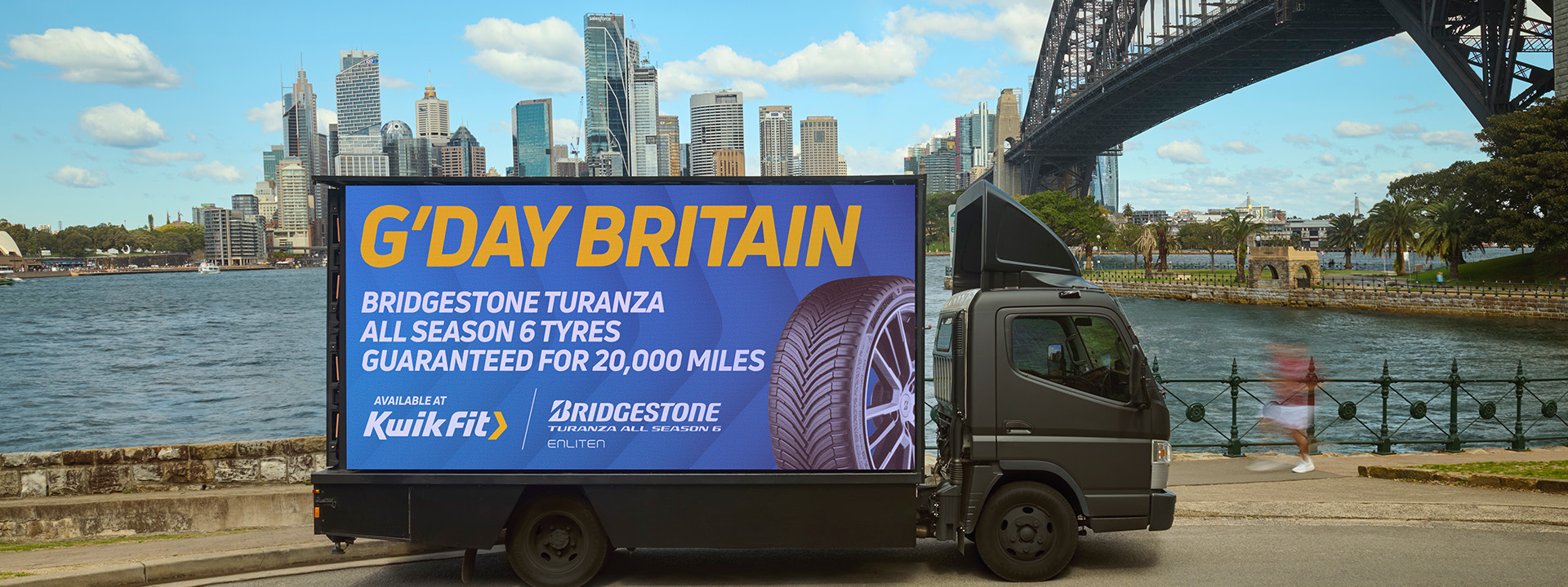Lorry truck outside Sydney harbour bridge with Kwik Fit branding.