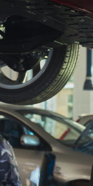 Department for Education campaign - Senior mechanic teaching a young person about fixing cars