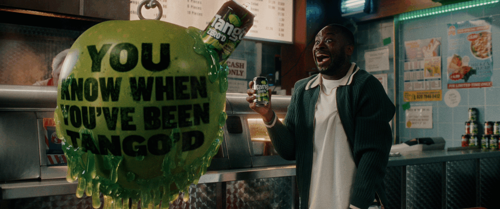 Happy man drinking Tango soft drink and a giant apple shaped wrecking ball