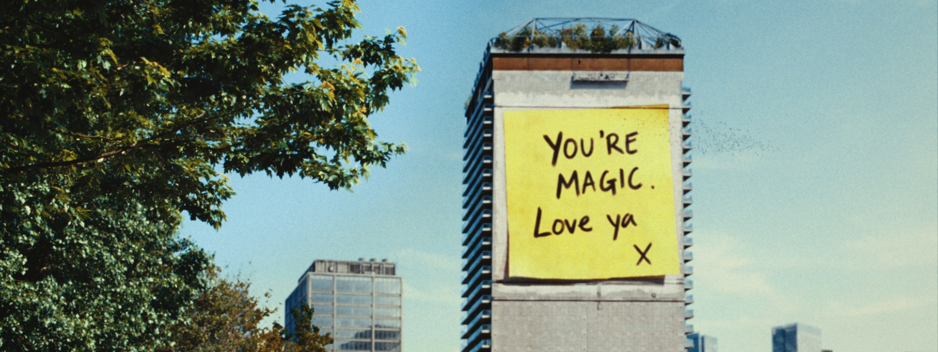 Building with large post note with 'You're Magic, love you' for Allwyn, Powerball campaign