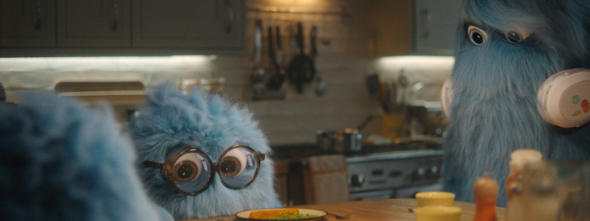 fluffy blue character at dinner table