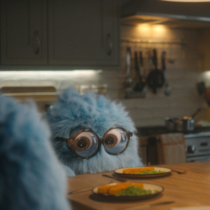fluffy blue character at dinner table