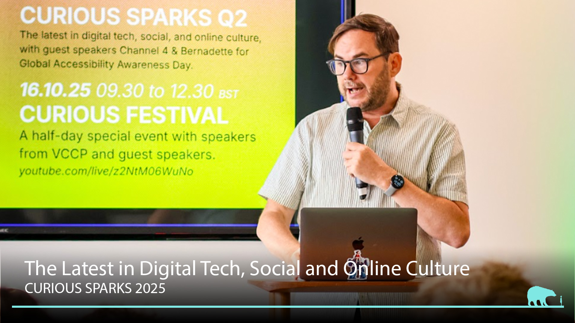 Peter Gasston speaking into a microphone at the Curious Sparks 2025 event on digital tech and online culture.