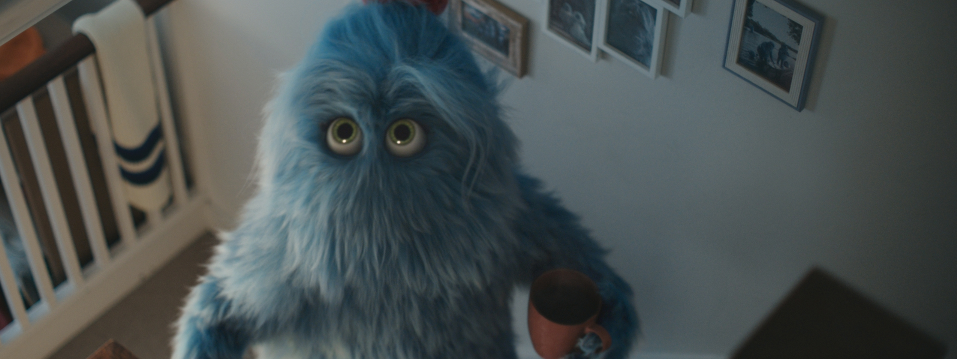 Large blue furry monster character holding a mug in a hallway for British Gas ad campaign.