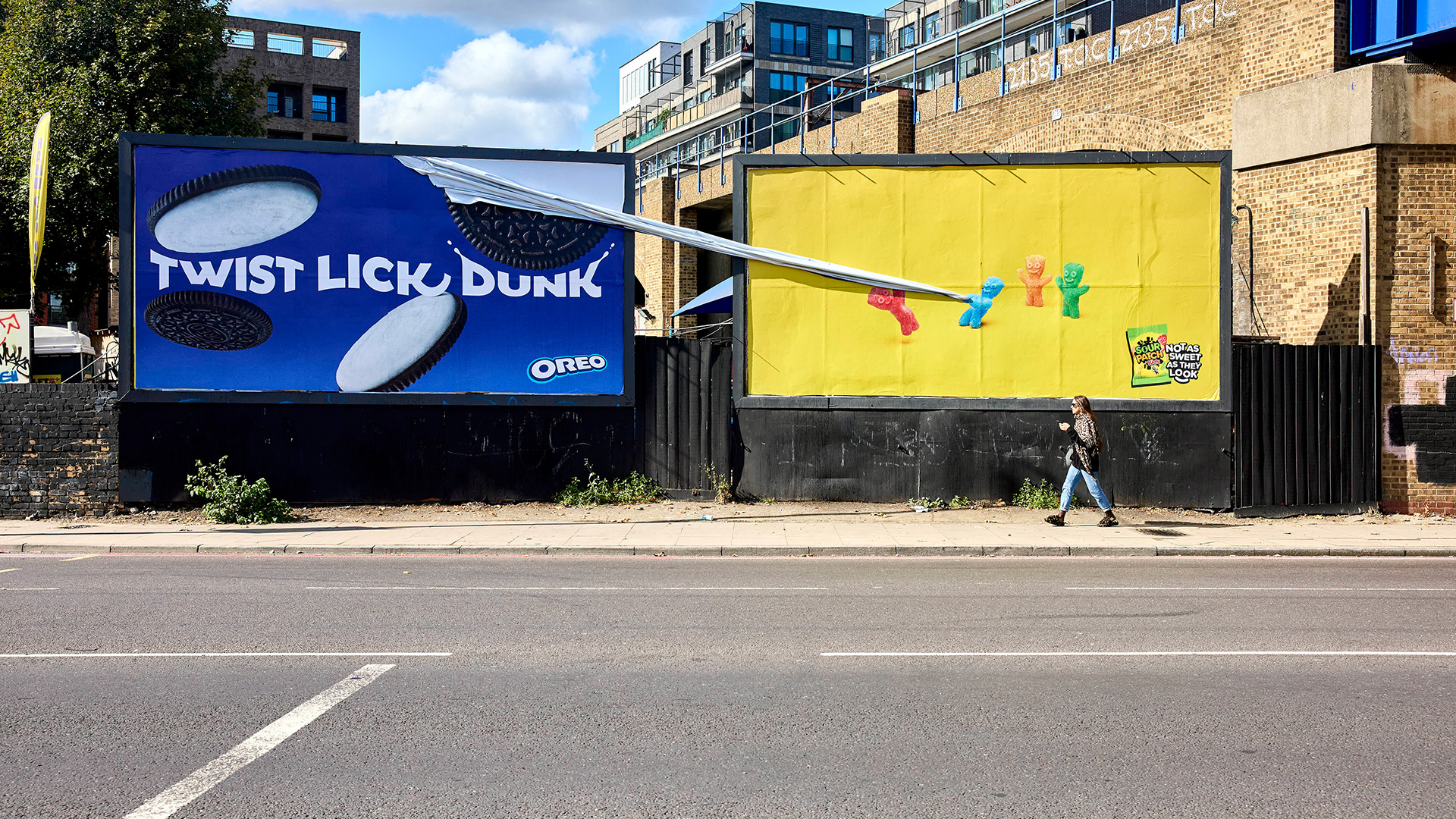 Interactive Sour Patch Kids billboard pulling a plastic wrapper extension off an adjacent Oreo billboard advertisement.