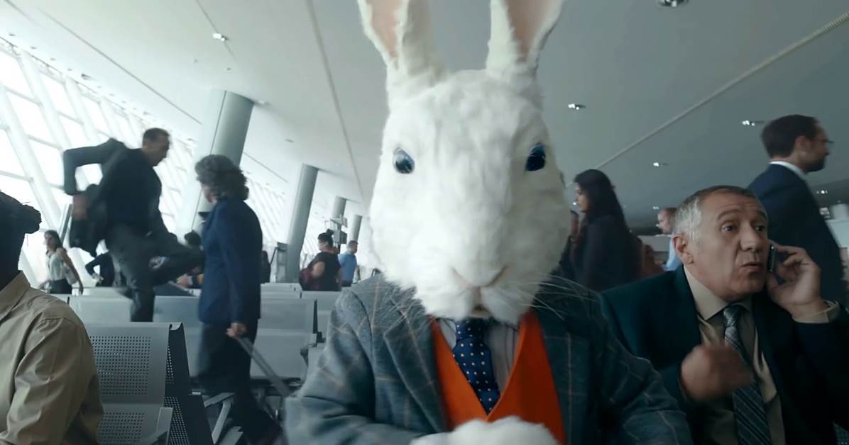 A large white rabbit in a room full of people