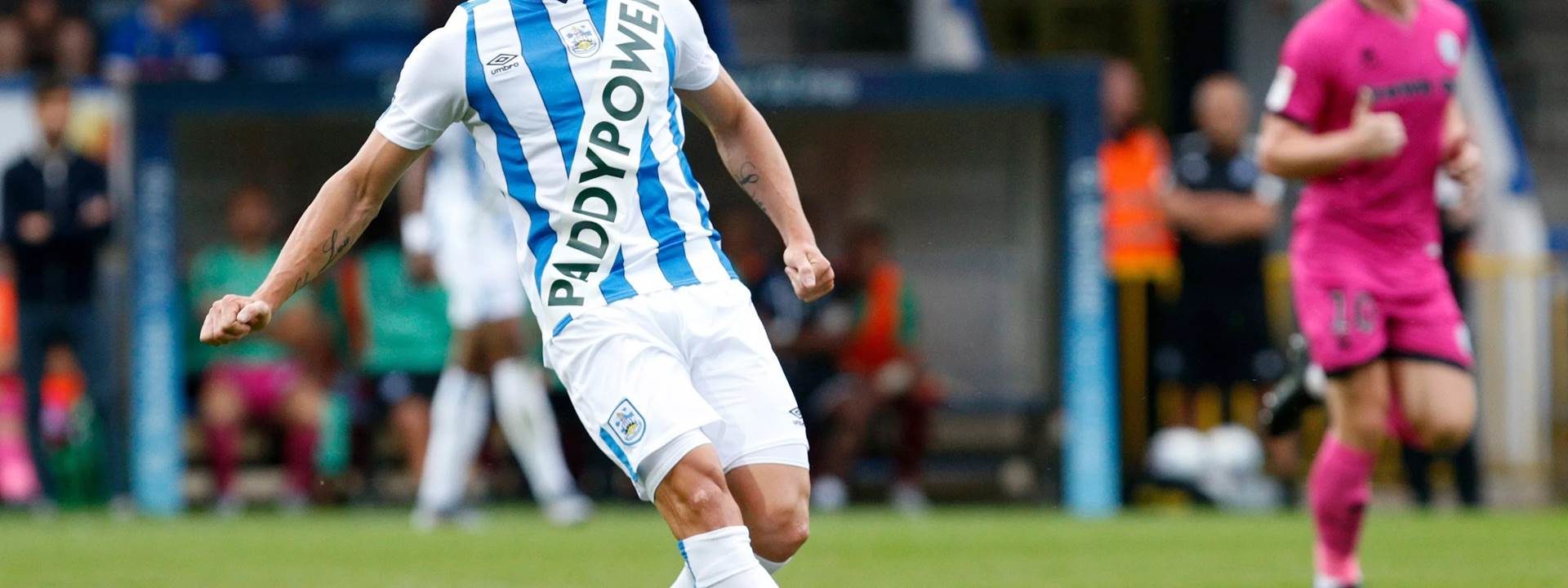 A soccer player with a blue and white striped tshirt that reads Paddy Power