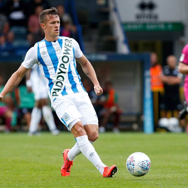 A soccer player with a blue and white striped tshirt that reads Paddy Power