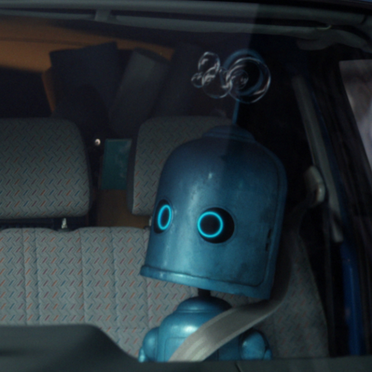 A close up of a robot in the front seat of a van