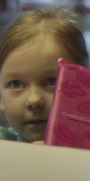 Closeup of a little girl holding a pink packaged chocolate bar