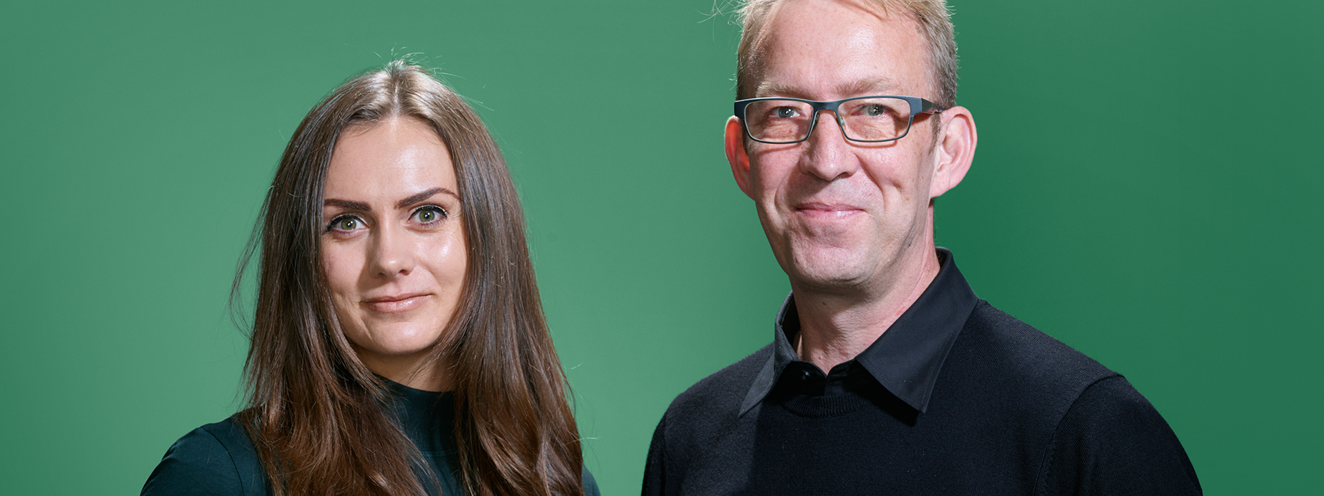 Ellen and Jakes standing together against a green background.